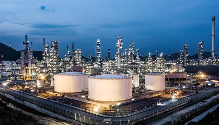 Aerial view oil storage tank and oil refinery factory plant at night, Refinery factory oil storage tank and pipeline steel at night, Oil and Gas petrochemical industrial.